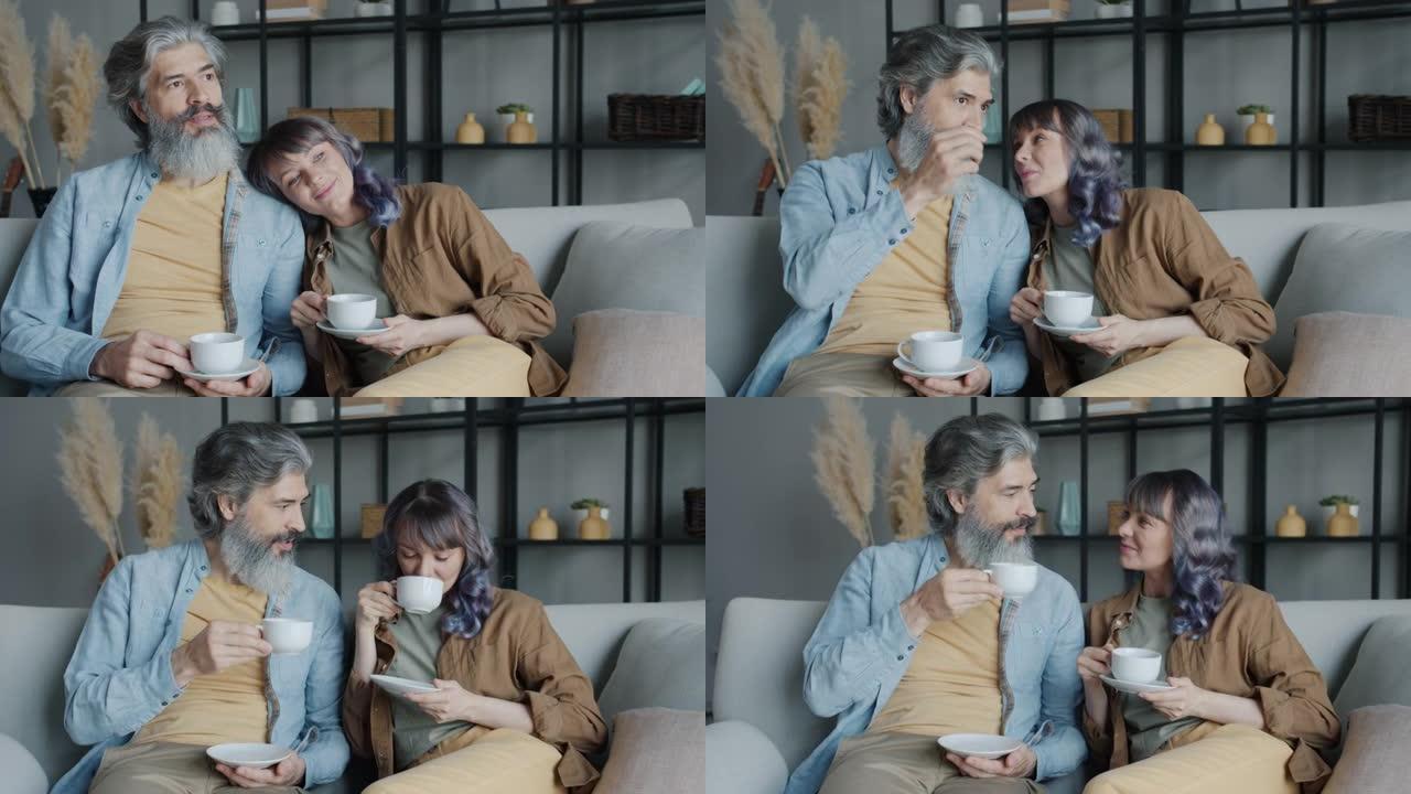 成熟男人和中年女人在家里的沙发上喝咖啡和聊天放松