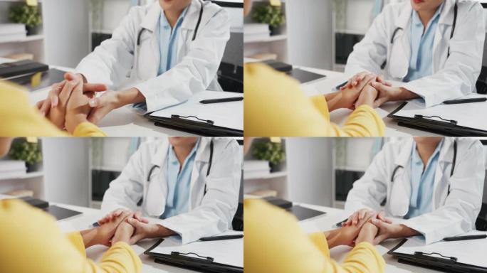 穿着白色医疗制服的年轻亚洲女医生的特写镜头讨论在诊所或医院办公室坐在办公桌前的会议上触摸女孩病人的肩