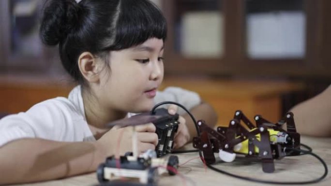 女孩学习在家中构建和固定机器人玩具干研究