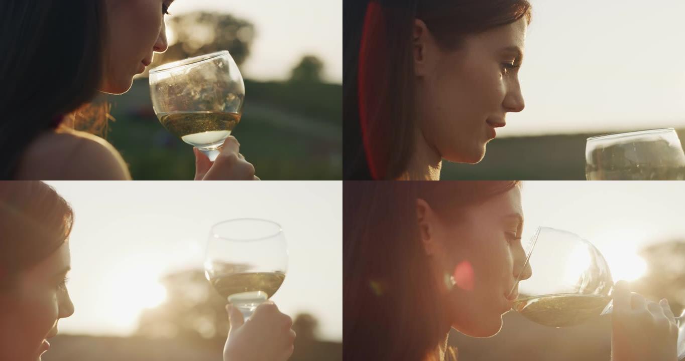 在日落时分，风景秀丽的葡萄园背景上品尝着一种味道，喝着倒入透明玻璃杯中的白葡萄酒。