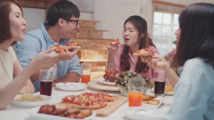 快乐的亚洲朋友在家里一起吃披萨，朋友用餐概念