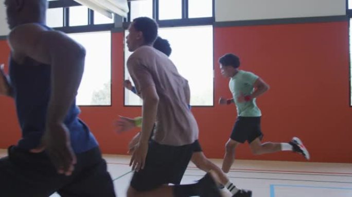 多样化的男子篮球队和教练跑步和穿着运动服