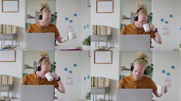 白化病非裔美国男子，长发lock喝咖啡，在笔记本电脑上进行视频通话