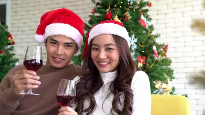 Dolly Shot: 年轻的成年亚洲夫妇用葡萄酒庆祝圣诞节