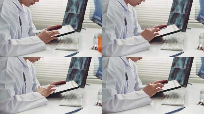 女医生在医院的桌子上使用平板电脑