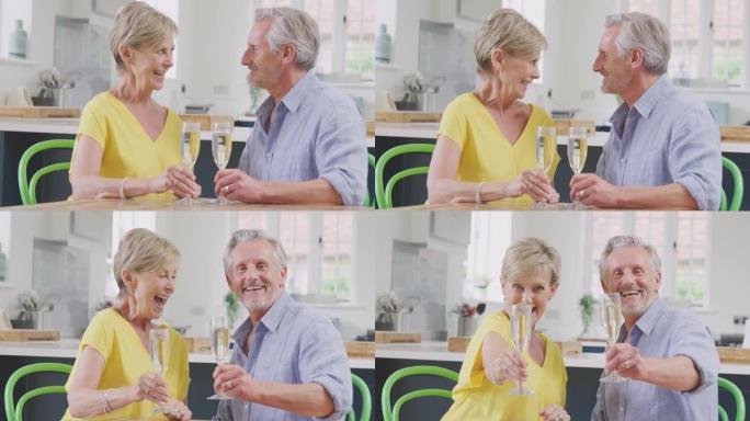 退休的高级夫妇在家里一起用一杯香槟向相机敬酒庆祝