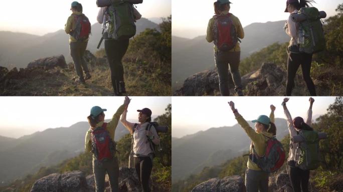 两个带着野营背包的女徒步旅行者步行和徒步到山顶