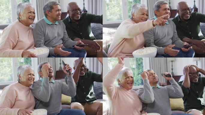快乐的混血儿高级夫妇和非裔美国朋友用爆米花看电视