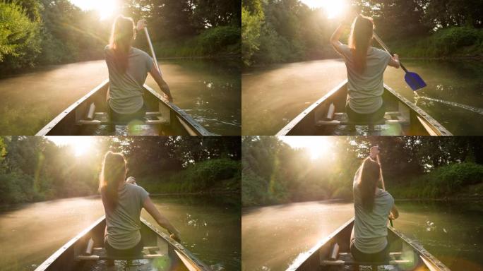 年轻女子在平静的绿色河上的独木舟上放松