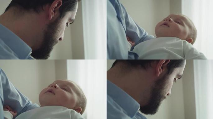 年轻的和平父亲的电影特写镜头拥抱着他刚出生的男婴，同时在日光下睡在窗户上。甜梦，童年，生活，父亲身份