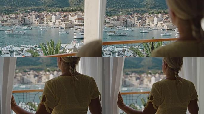 在海边的阳台上欣赏风景的SLO MO女人