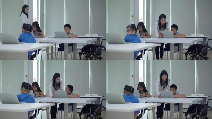 亚洲青年女教师残疾男孩年龄10岁在小学教室学习电脑。残疾收集2019