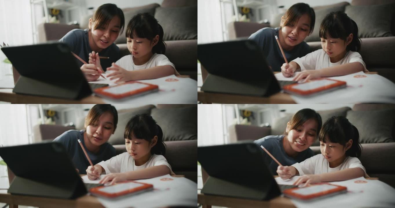 母亲帮助女儿在家上学时使用笔记本电脑