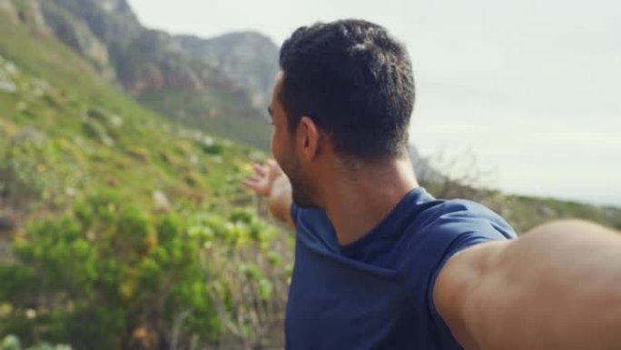 一个快乐男人徒步旅行的肖像，一边自拍一边指着风景，一边打视频。面对一名年轻的拉丁裔游客，在大自然的跋