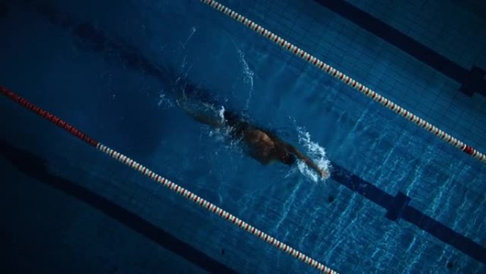 空中俯视图: 游泳池中肌肉发达的男性游泳者。专业运动员以仰泳的方式游泳，决心赢得冠军。深色戏剧色彩，