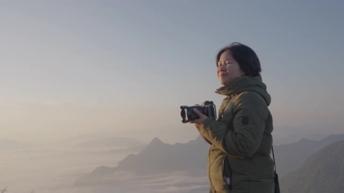 女性背包客无忧无虑地在摄影之旅中捕捉迷雾山的图像。