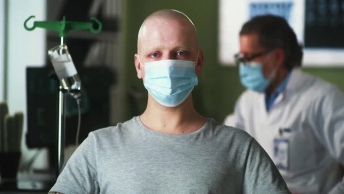 戴着面具的秃头男子在化疗期间看着相机