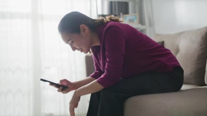 女人在家沙发上使用智能手机