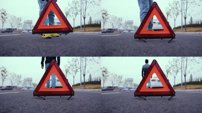 男子在道路上放置红色警告三角形