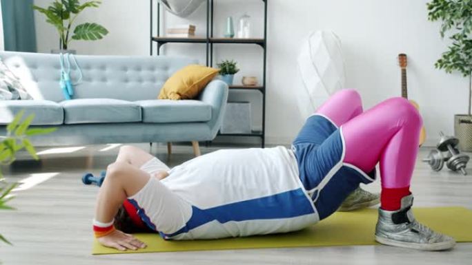 胖乎乎的家伙慢动作在螃蟹姿势训练，然后在家室内在瑜伽垫上放松