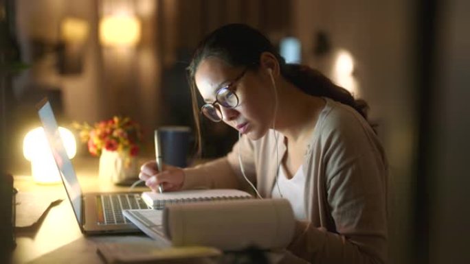 亚洲女性晚上在家用笔记本电脑学习