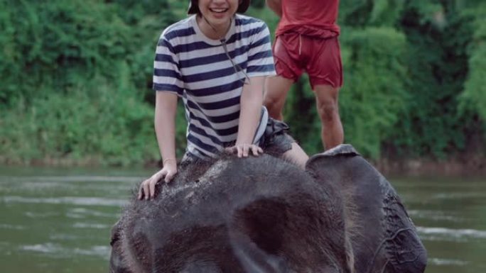 在泰国河上骑大象的女人