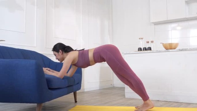 亚洲妇女在家沙发上锻炼