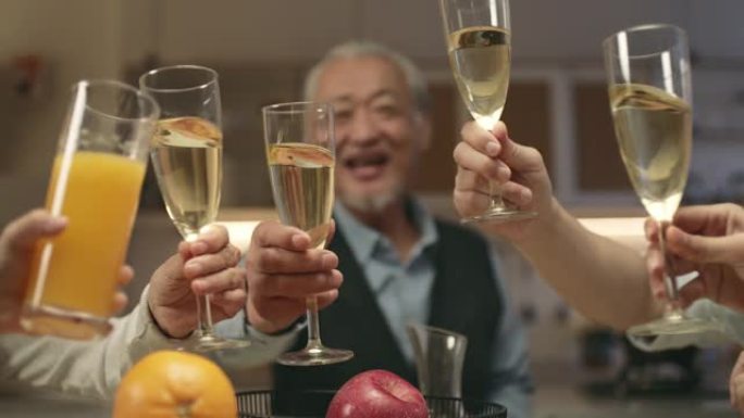 亚洲高级男子在家庭聚会期间敬酒