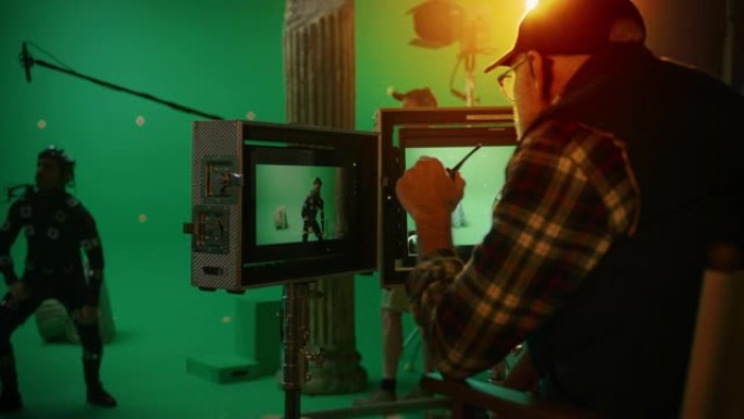 导演看显示器，演员穿着运动跟踪服和头部装备，指导绿屏CGI场景。在大电影制片厂专业剧组拍摄大片