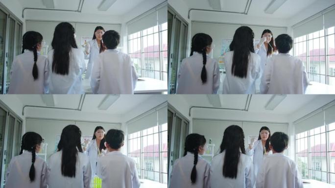 科学家老师在学校的实验室课上与小学生讲话。