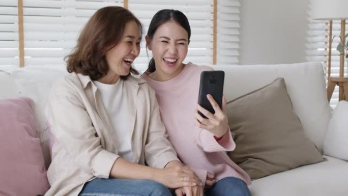 快乐好玩有趣的亚洲家庭自拍手机父母家庭有趣的微笑。