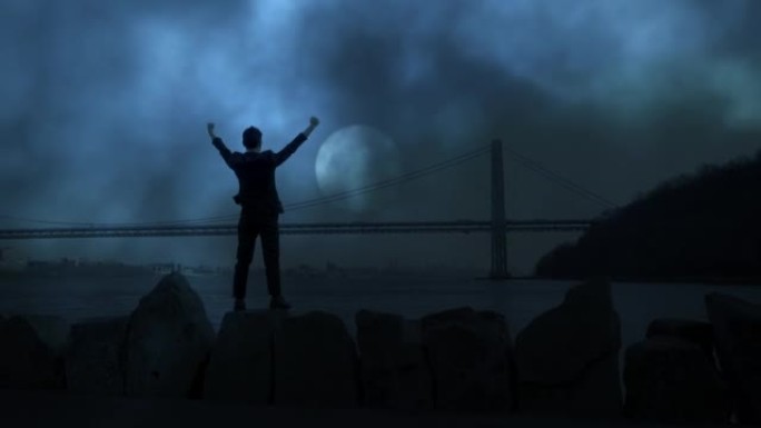 一名男子站在户外，双臂举起，做着胜利的姿势，展示了夜空中成功的生活方式
