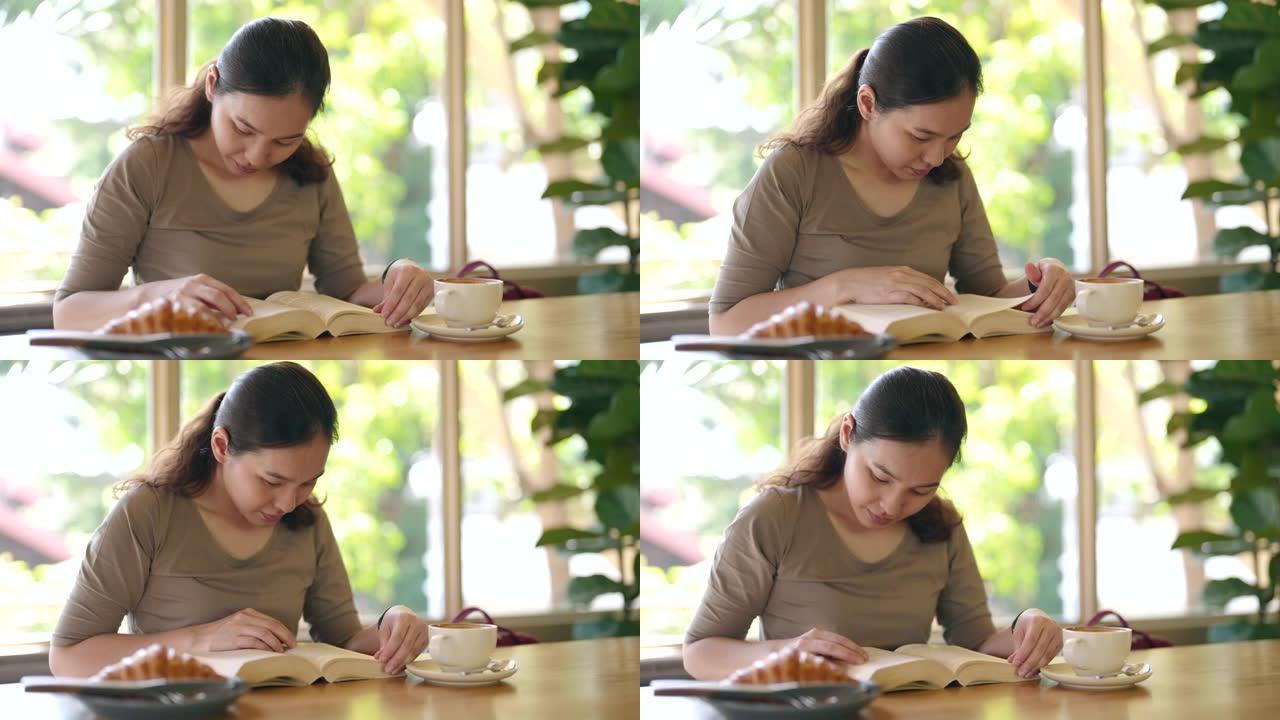 一个喝咖啡放松的女人，亚洲女人在咖啡馆看书喝冰咖啡