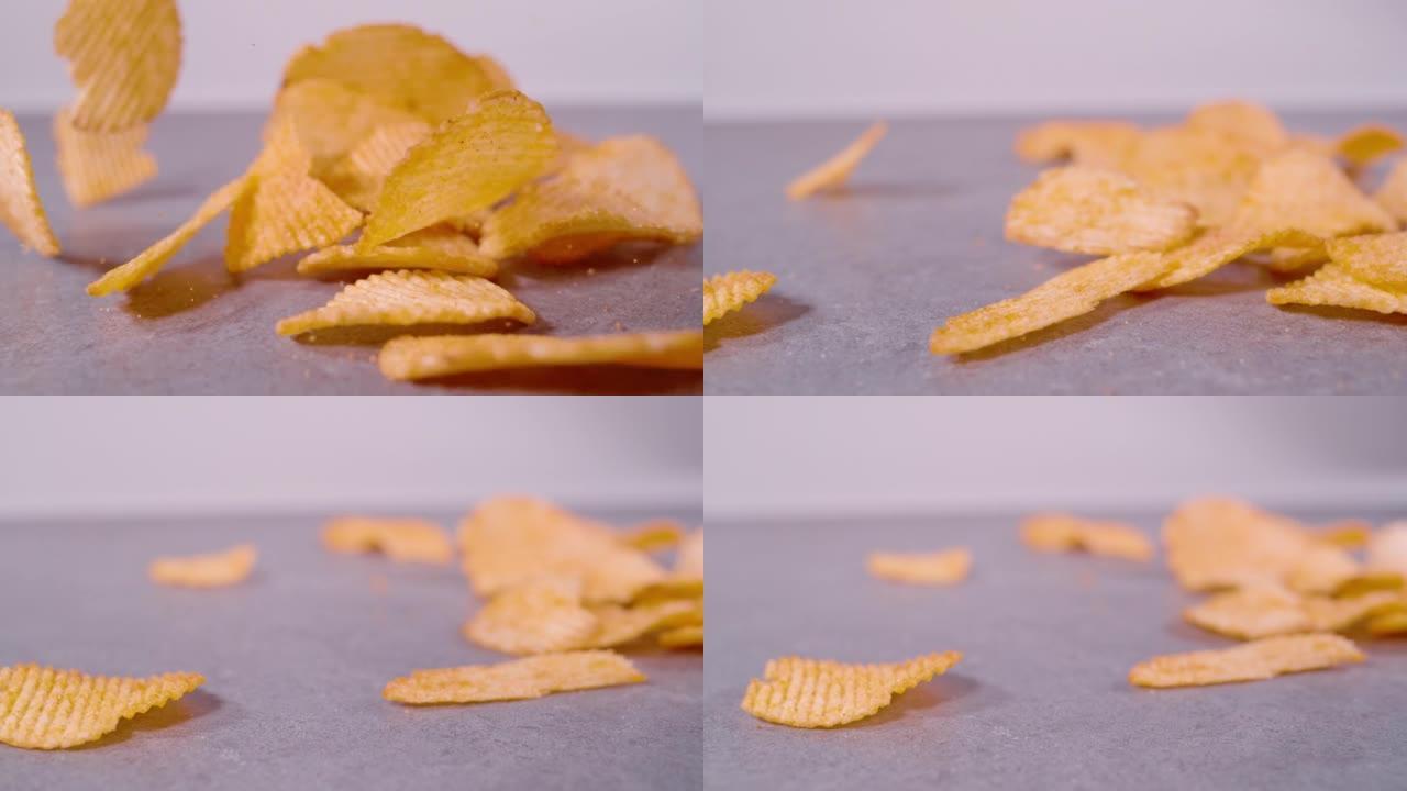 慢动作，特写: 在灰色背景上慢动作掉落的薯片