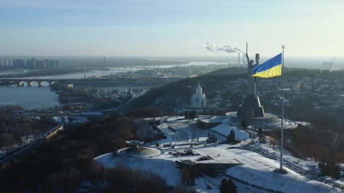 在第聂伯河的基辅，壮丽的乌克兰国旗在史诗般的祖国雕像纪念碑前飘扬的电影航拍全景。