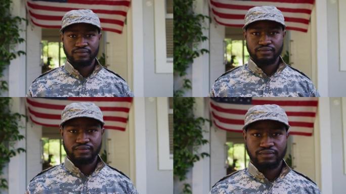 非裔美国男性士兵站在房子和美国国旗前的肖像