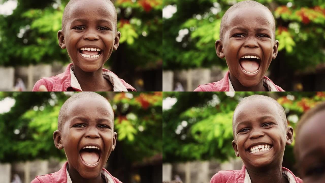 一个富有表现力的真实非洲孩子的特写肖像，笑着看着模糊的相机背景。快乐，精力充沛，充满活力的黑人男孩快