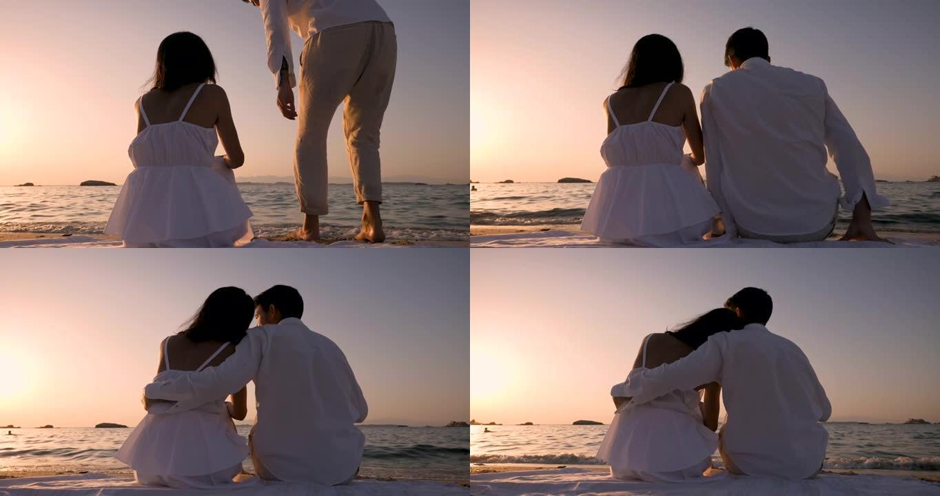 一对年轻无忧无虑的幸福夫妇的真实照片是玩得开心，日落时在海边海滩一起享受他们的暑假浪漫假期。