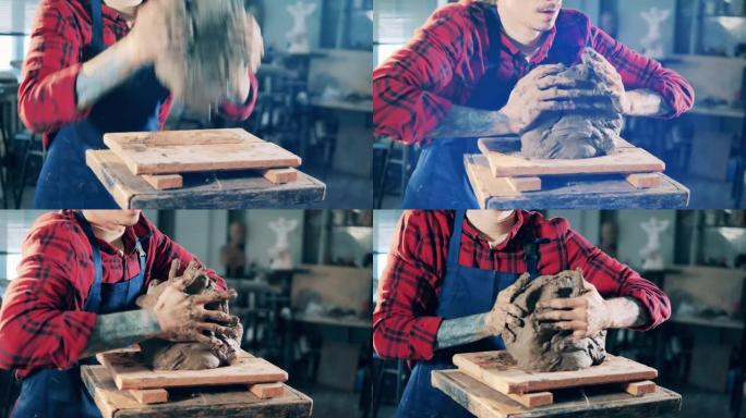 男雕塑家正在拿一块粘土并开始揉捏