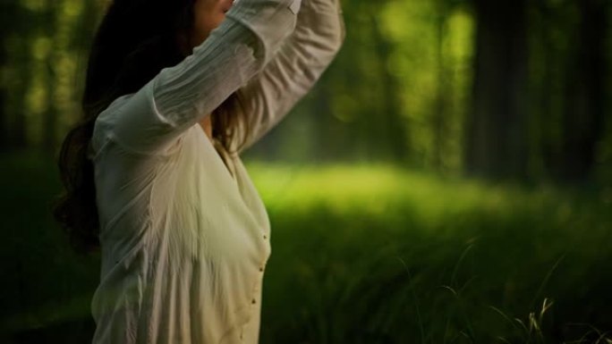 SLO MO年轻女子在朦胧的绿色森林中冥想
