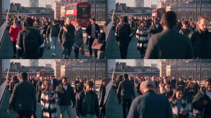 拥挤的通勤者在高峰时段在伦敦市中心区伦敦桥上行走的慢动作镜头
