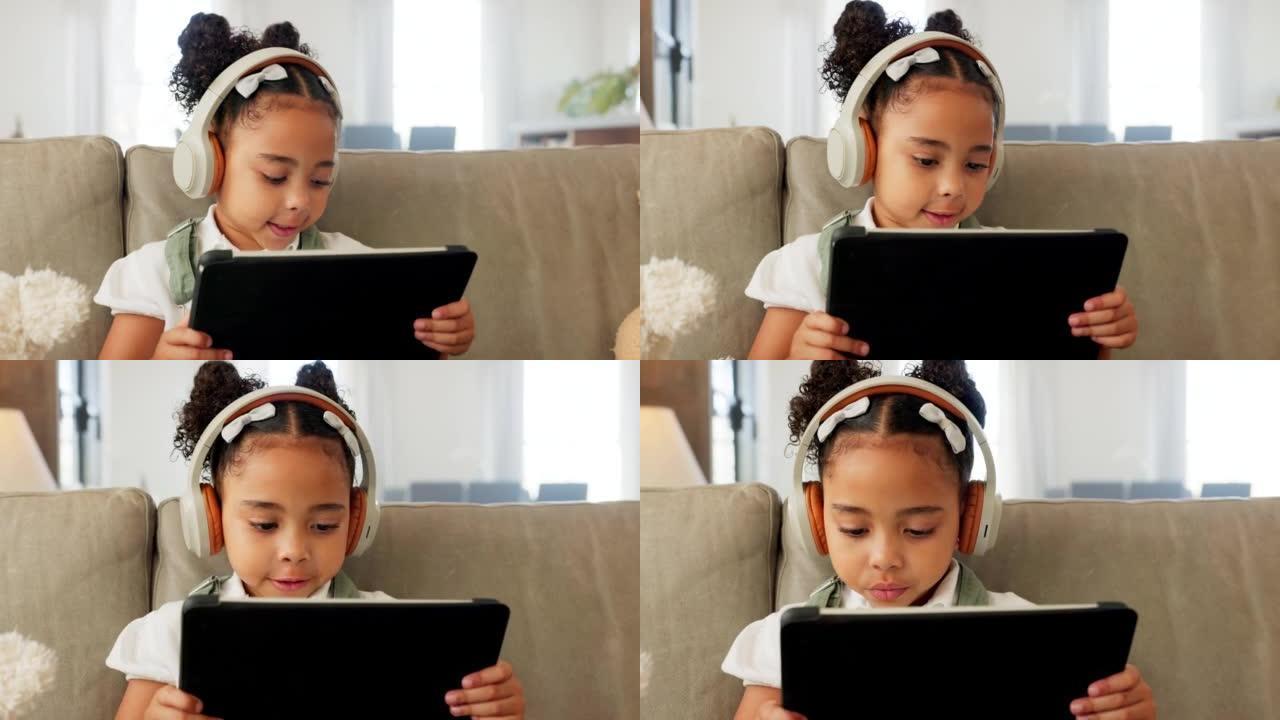 平板电脑，耳机和带e学习应用程序的儿童，在网站上观看儿童视频或在家沙发上的在线教育。女孩在客厅沙发上