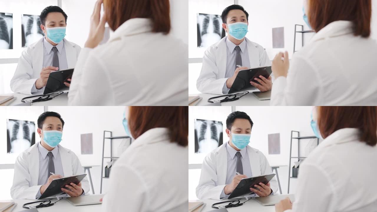 严重的亚洲男性医生戴防护口罩使用剪贴板正在传递重大新闻谈话与医院办公室的女性患者讨论结果或症状。