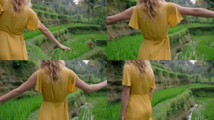 快乐的女人穿着黄色连衣裙走在稻田里享受假期探索异国文化景观穿越印度尼西亚巴厘岛