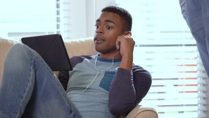 男人在家中使用平板电脑，被打断，对伴侣微笑