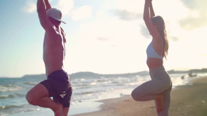 情侣瑜伽在海滩上伸展
