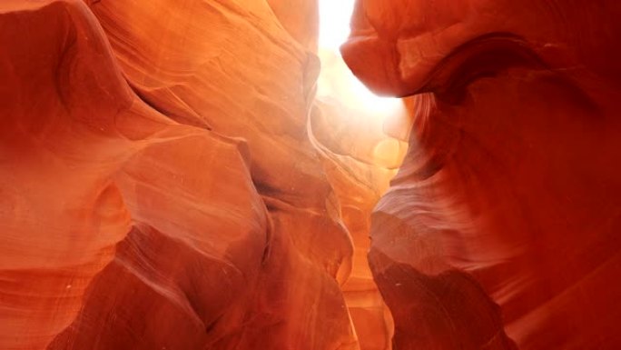 美国亚利桑那州羚羊峡谷橙色砂岩岩石周围漂浮的尘埃。阳光普照。Steadicam镜头，4K