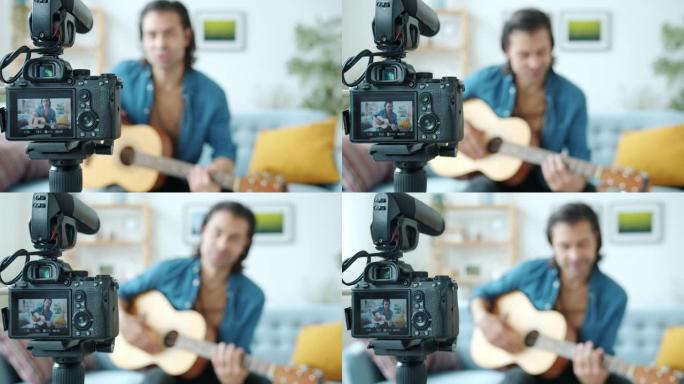 摄像机屏幕和吉他手vlogger在背景中录制视频的特写