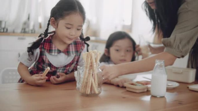 亚洲男孩和女孩早上上学前吃早餐。