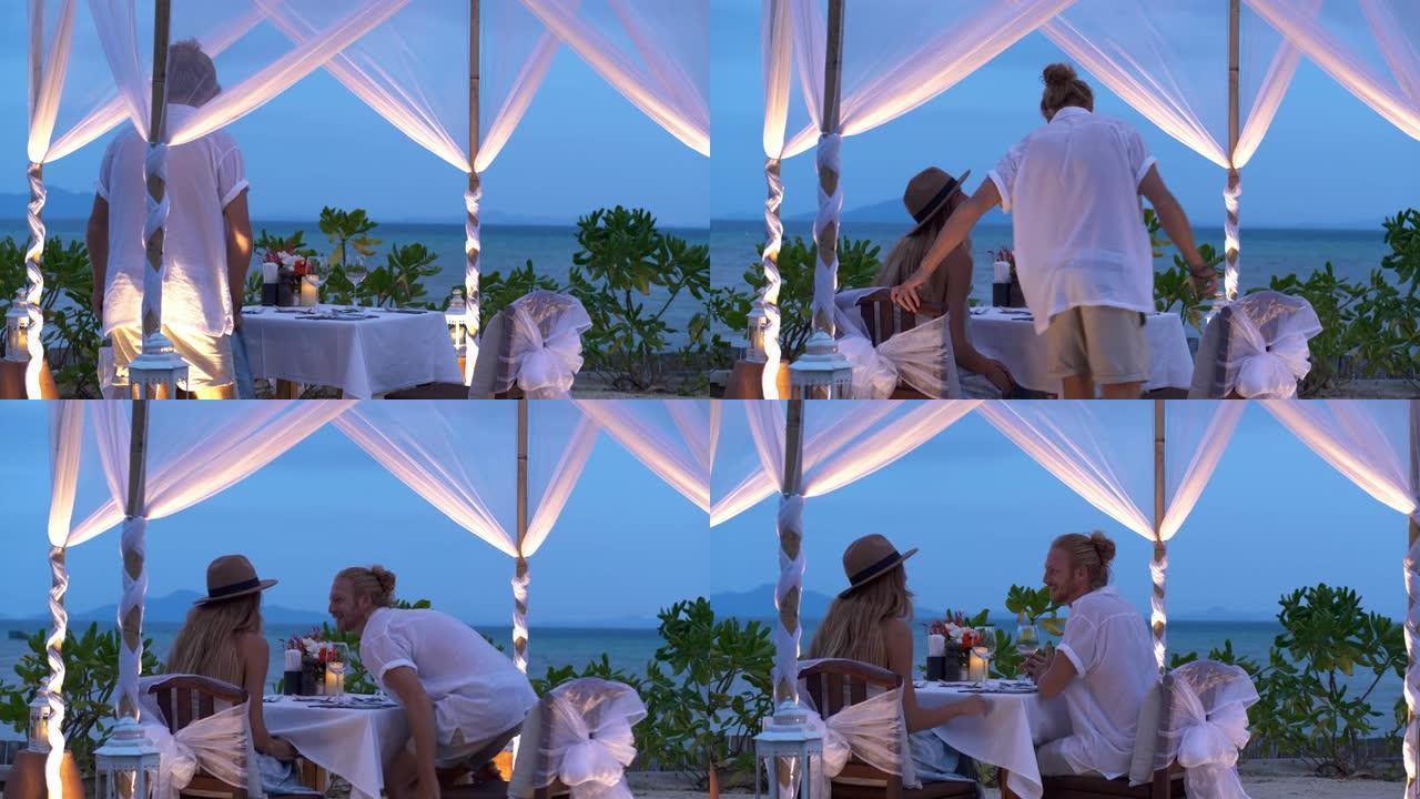 25岁的甜蜜年轻夫妇的奢华浪漫，在情人节在海景沙滩上度过浪漫的晚餐，度过美好的黄昏。。非高加索蜜月概
